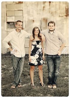 three people standing next to each other in front of an old building