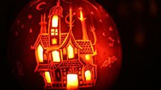 a carved pumpkin with an image of a church on it