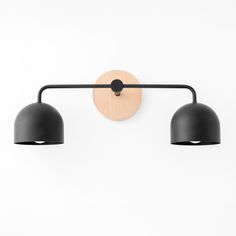 two black lamps mounted on the wall next to each other