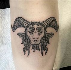 a black and white image of a horned goat with long horns on the leg,