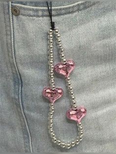 a pair of pink heart shaped beads hanging from the back of someone's jeans