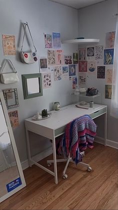 a room with a desk, mirror and pictures on the wall above it is shown