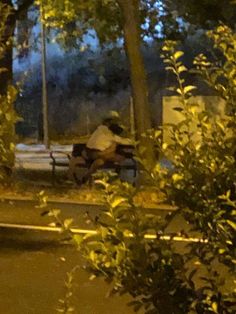 two people sitting on a park bench at night