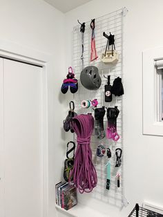 there is a rack with many items hanging on the wall next to a door and window