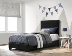 a bedroom with white walls and black furniture