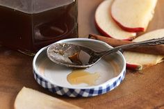 an apple jam in a bowl next to sliced apples on a cutting board with a spoon