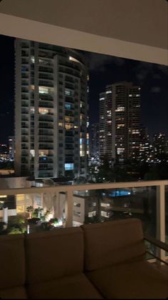 a couch sitting on top of a balcony next to tall buildings