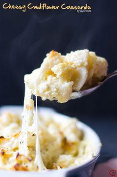 a spoon full of mashed potatoes being lifted from a bowl with the casserole in it