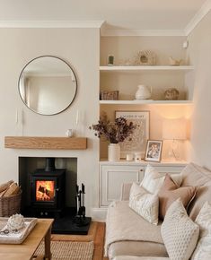 a living room filled with furniture and a fire place in front of a wall mounted mirror