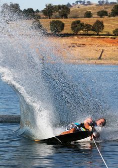 a man riding skis on top of a lake next to a boat in the water