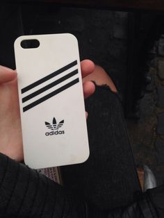 someone is holding up their phone case with the adidas logo on it