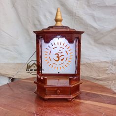 a small wooden clock with a white and orange design on it's face sitting on a table