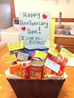 a basket filled with lots of food sitting on top of a table next to a sign