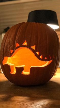 a pumpkin carved to look like a dinosaur