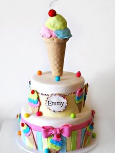 a birthday cake with an ice cream cone on top and colorful decorations around the edges