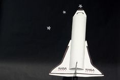 a model of the space shuttle is shown in front of a black background with stars