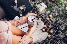 a woman sitting on the floor holding a cup of coffee