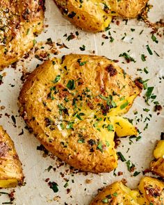 baked potatoes with herbs and seasoning on a sheet of parchment paper, ready to be eaten