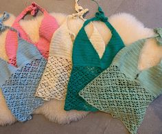 four knitted bras laying on top of a white rug next to each other