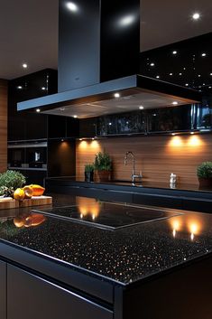 a modern kitchen with black counter tops and lights on the wall above it's sink