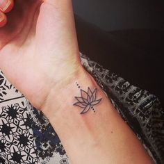 a woman's arm with a small tattoo on it, and a flower in the middle