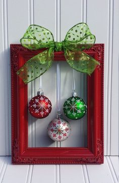 an image of christmas ornaments in a red frame on the wall with green ribbon and bow