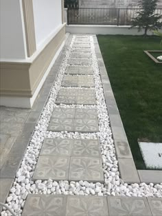 a walkway made out of stones with grass in the background