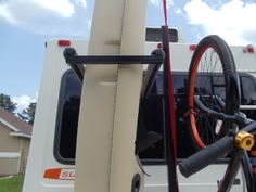 a bicycle is strapped to the back of a camper van with its door open