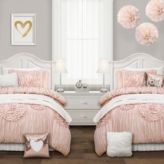 two white beds with pink comforters and pillows