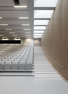 an empty auditorium with rows of white chairs