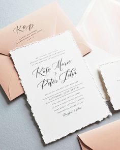 the wedding stationery is laid out on top of each other