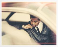 a man sitting in the driver's seat of a car looking at his watch