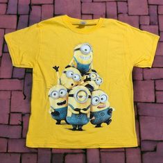 Heavy Cotton Yellow T-Shirt Featuring Minions Size Adult M 100% Heavy Cotton Armpit To Armpit 19" Shoulder To Hem 24" Double Stitched Seams, Bias Covered Seam At Collar Nwot, New, Never Worn Smoke Free Pet Free Environment Yellow Cartoon Print T-shirt For Summer, Yellow Crew Neck T-shirt With Cartoon Print, Yellow T-shirt With Character Print, Yellow Graphic Tee With Character Print, Fun Yellow T-shirt For Summer, Yellow Short Sleeve Top With Character Print, Casual Yellow Short Sleeve T-shirt, Yellow Graphic Tee With Crew Neck, Fun Yellow Tops With Character Print