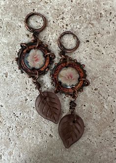 Artisan made enameled copper components with image of flowers, inside aged copper rings, and wire wrapped Czech glass leaves in autumnal color below. Completed with antique copper lever back ear wires. Very light weight. So dainty and pretty! Artsy Brown Copper Jewelry, Vintage Hand Painted Brown Jewelry, Hand Painted Brown Vintage Jewelry, Vintage Brown Hand Painted Jewelry, Brown Hand Painted Vintage Jewelry, Artsy Hand Painted Copper Jewelry, Vintage Handmade Rust Jewelry, Artistic Hand Painted Brown Jewelry, Artistic Brown Copper Jewelry