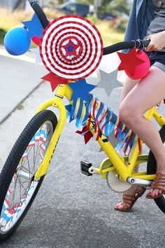 a person riding a yellow bike with red, white and blue decorations on the front wheel