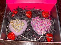 two heart shaped chocolates in a pink box with confetti and sprinkles