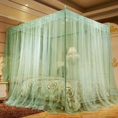 a bedroom with a bed covered in green sheer curtains and a chandelier hanging from the ceiling