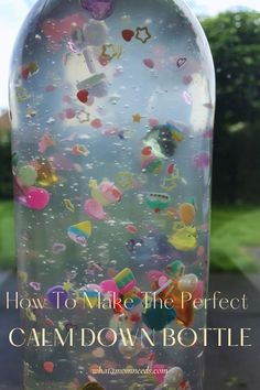 a bottle filled with lots of confetti on top of a window sill