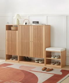 a wooden cabinet sitting on top of a rug next to a lamp and shoeshelf