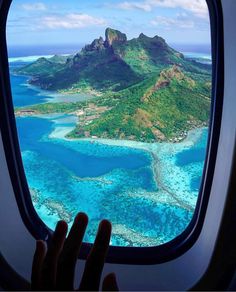 an airplane window with the view of some water and land