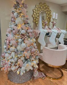 a pink and white christmas tree in the corner of a room with gold trimmings