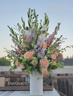 a vase filled with lots of flowers on top of a table