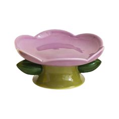 a pink flower shaped bowl sitting on top of a green base