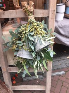 a wooden chair with a bunch of flowers and bells on it's back legs