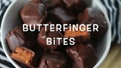 a white bowl filled with chocolate covered peanut butter bites next to a black and white striped napkin