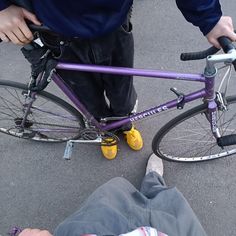 a person sitting on the ground next to a purple bike