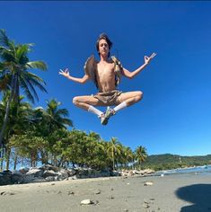 a man is jumping in the air with his feet spread out and arms wide open