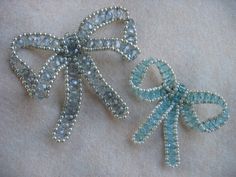 two brooches with bows made out of beads