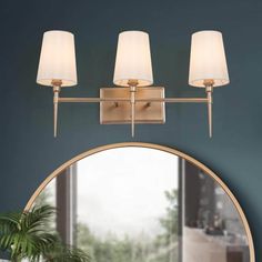 a bathroom vanity light with three lights and a round mirror in front of the wall