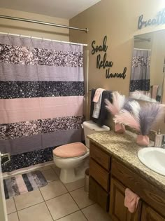 a bathroom with a sink, toilet and shower curtain in it's center area